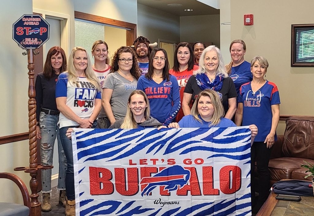 Northtowns Oral Surgery team photo - with Buffalo Bills banner and garb