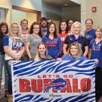 Northtowns Oral Surgery team photo - with Buffalo Bills banner and garb