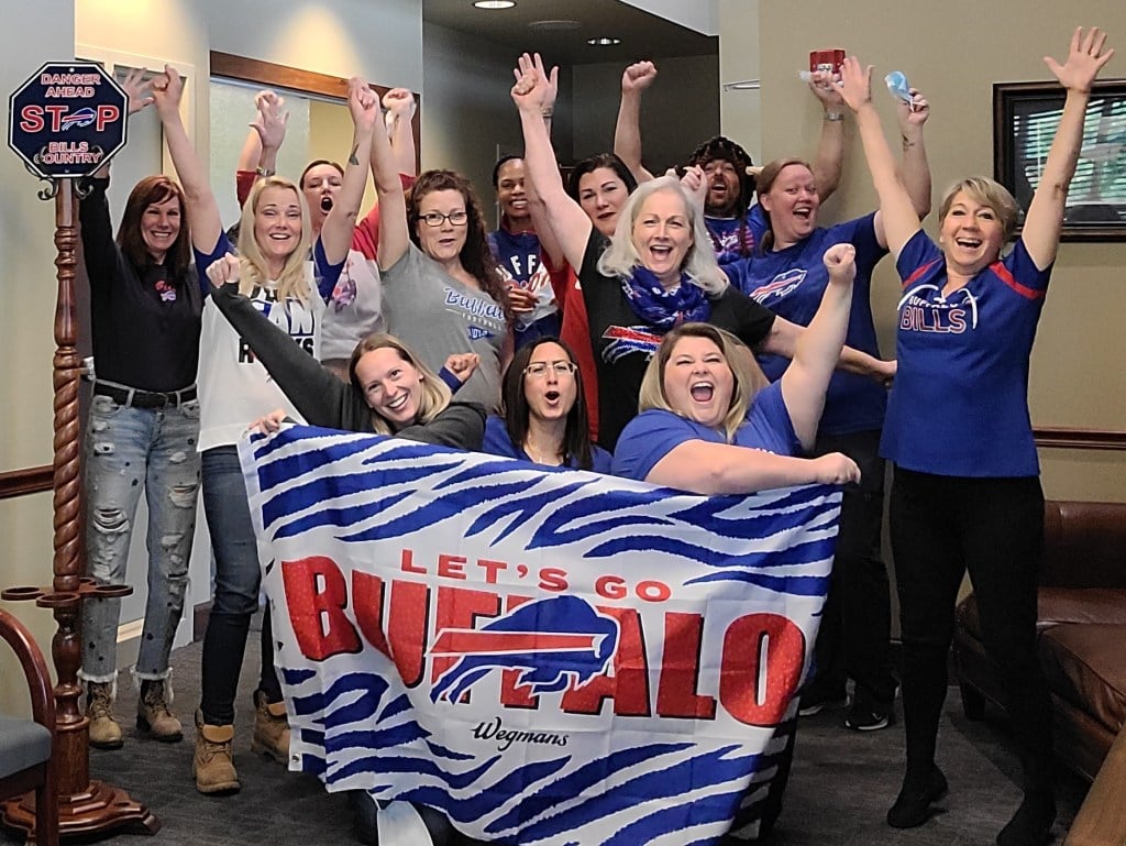 Northtowns Oral Surgery team photo - with Buffalo Bills banner and garb